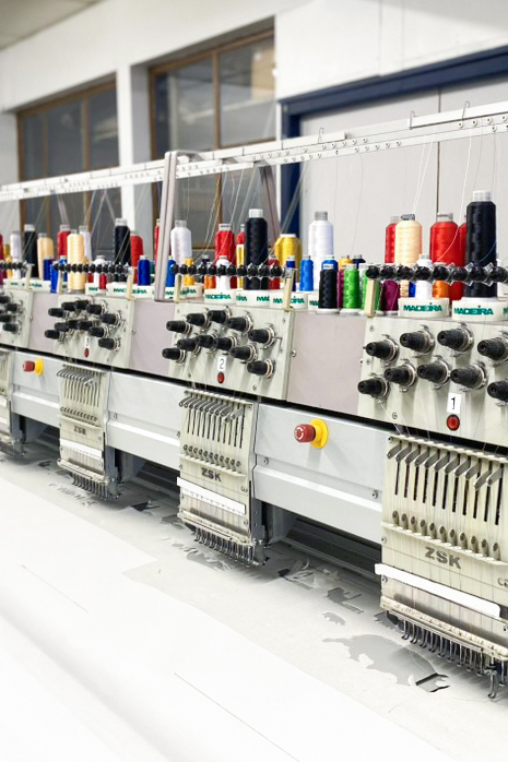 Machine de broderie industrielle multi-têtes dans l’atelier Stitch Box.